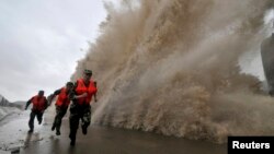 Para tentara berlari saat gelombang besar yang dipicu oleh topan Fitow menghantam garis pantai di Wenling, provinsi Zhejiang (6/10).