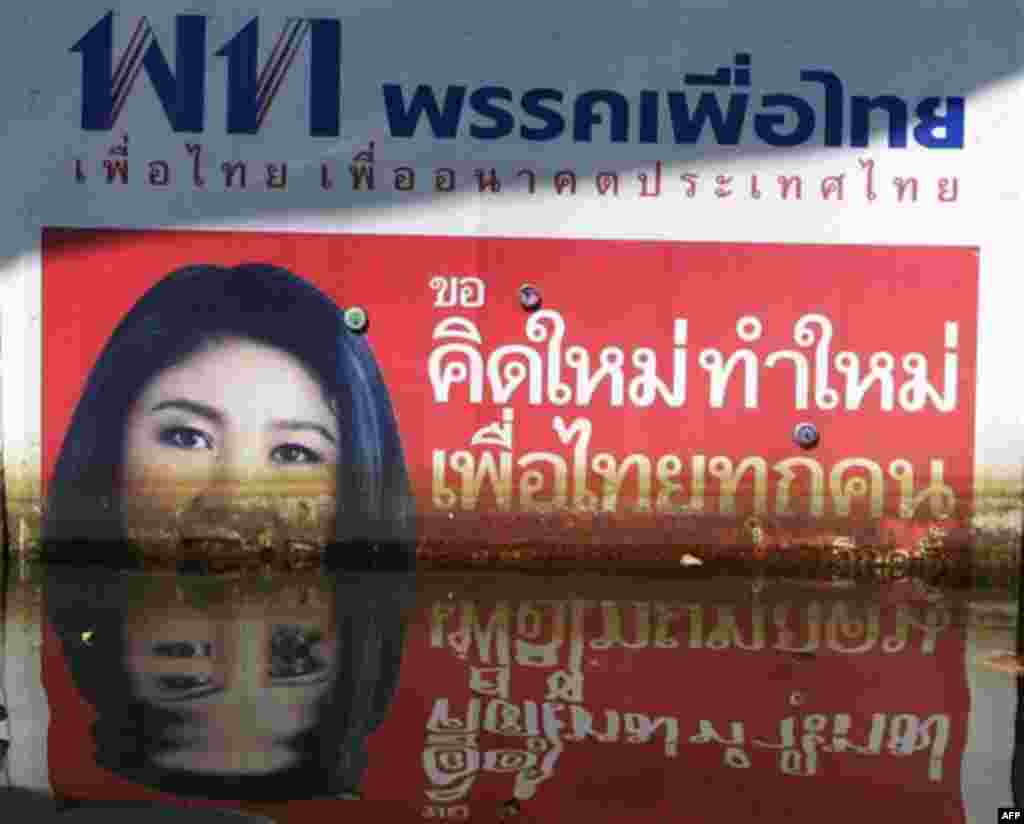 A poster of Pheu Thai party leader and Thailand's Prime Minister Yingluck Shinawatra sinks under floodwaters at Phisi Charoen district in Bangkok, Thailand, Saturday, Nov. 12, 2011. Yingluck has struck a note of partial optimism over the floods plaguing 