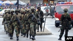 Liberian army soldiers walk on the Monrovia bridge during a training excercise as the United Nations Mission in Liberia forces (UNMIL) finally hands back security to Liberia's military and police, in Monrovia on June 24, 2016.