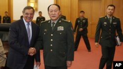 U.S. Defense Secretary Leon Panetta, left, and Chinese Defense Minister Liang Guanglie shake hands before their delegations meet at the Bayi Building in Beijing, China, September 18, 2012.