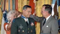 FILE - President George Bush loans his glasses to first lady Barbara Bush as she pins a Medal of Freedom on Gen. Colin Powell, chairman of the Joint Chiefs of Staff, during a White House ceremony, July 3, 1991.