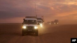 This photo released by the Syrian Arab Red Crescent, shows a convoy of vehicles of the Syrian Arab Red Crescent driving in the Syrian desert heading to Rukban camp between the Jordan and Syria borders, Nov. 4, 2018.