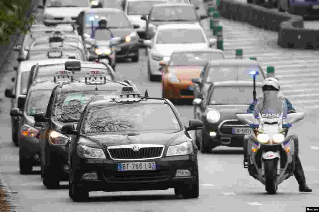 French motorcycle police escort striking Paris taxis which take part in a demonstration over the Paris ring road, Dec. 15, 2014.