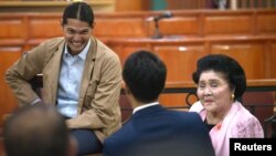 Mantan Ibu Negara Filipina Imelda Marcos berbincang dengan cucu laki-lakinya setelah bersaksi di pengadilan tipikor Filipina di Sandiganbayan in Quezon City, Metro Manila, Filipina, 16 November 2018.