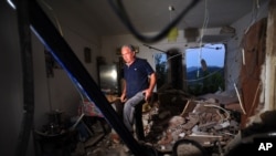 A man walks inside a destroyed house after an earthquake at the village of Pothi on the western Greek island of Lefkada, Nov. 17, 2015.