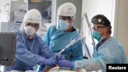 Dr. Dan Ponticiello, 43, and Dr. Gabriel Gomez, 40, intubate a coronavirus disease (COVID-19) patient in the COVID-19 ICU at Providence Mission Hospital in Mission Viejo, California, U.S., January 8, 2021. 