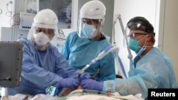 ကယ်လီဖိုးနီးယား ဆေးရုံတခုက အထူးကြပ်မတ်ကုသဆောင်မှာ ကိုဗစ်လူနာကို ပြုစုကုသပေးနေတဲ့ ကျန်းမာရေးဝန်ထမ်းများ။ (ဇန်နဝါရီ ၈၊ ၂၀၂၁)
