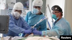 ကယ်လီဖိုးနီးယား ဆေးရုံတခုမှာ ကိုဗစ်လူနာကို ပြုစုကုသပေးနေတဲ့ ကျန်းမာရေးဝန်ထမ်းများ။ (ဇန်နဝါရီ ၈၊ ၂၀၂၁)