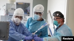 Dr. Dan Ponticiello, dhe Dr. Gabriel Gomez, duke vendosur në oksigjen një pacient me COVID-19 në pavionin e kujdesit intensiv në Spitalin Providence Mission, në Viejo, të Kalifornisë 