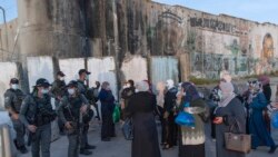 Palestinske žene čekaju da prijeđu kontrolni punkt Qalandia između grada Ramallah na zapadnoj obali i Jeruzalema, kako bi prisustvovale prvim molitvama petkom u džamiji al-Aqsa, tijekom muslimanskog svetog mjeseca Ramazana, u petak, 16. travnja 2021.