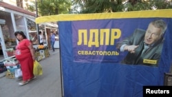 A woman walks past an election campaign poster of Vladimir Zhirinovsky, leader of Russian Liberal Democratic party, ahead of Sept. 18 parliamentary elections in the Black Sea port of Sevastopol, Crimea, Sept. 16, 2016.