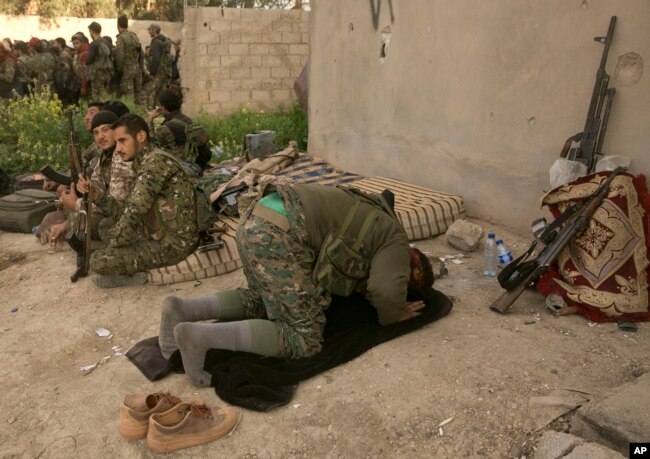 A U.S.-backed Syrian Democratic Forces fighter prays after returning from the front line in their fight against Islamic State militants in Baghuz, Syria, March 19, 2019.