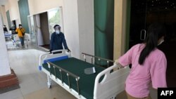 Members of the Cambodian military prepare beds for Covid-19 coronavirus patients at a wedding party hall in Koh Pich that is being turned into a field hospital in Phnom Penh on April 11, 2021. (Photo by TANG CHHIN Sothy / AFP)