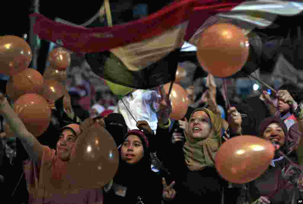Pendukung presiden terguling Mesir Mohamed Morsi memegang balon dan bendera nasional mereka dalam sebuah perayaan Idul Fitri di Kairo, 8 Agustus 2013.