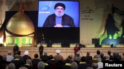 FILE - Lebanon's Hezbollah leader Sayyed Hassan Nasrallah addresses his supporters via a giant screen during a rally marking Hezbollah's Martyrs' Day in Beirut's suburbs, Lebanon.
