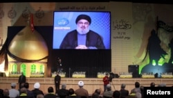 FILE - Lebanon's Hezbollah leader Sayyed Hassan Nasrallah addresses his supporters via a giant screen during a rally marking Hezbollah's Martyrs' Day in Beirut's suburbs, Lebanon.
