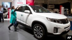 FILE - In this Jan. 10, 2013 photo, a worker polishes the new Kia Sorrento during the Brussels Motor Show at the Expo Center in Brussels.