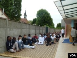 St. Etienne's mosque, next door to St. Therese, the Roman Catholic church that donated land for the mosque's construction, is thriving. An overflow group assembles outside for Friday prayers. (L. Ramirez/VOA)