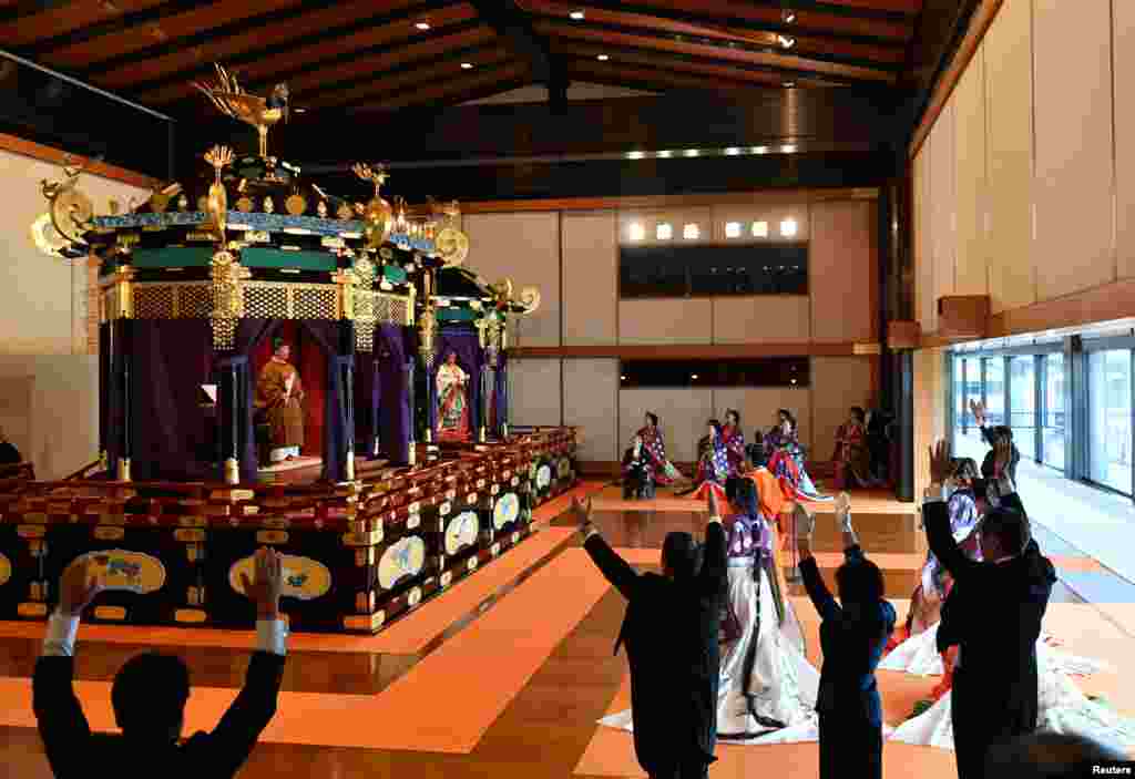 Japan&#39;s Prime Minister Shinzo Abe (R) shouts &quot;banzai&quot;, as he cheers for Emperor Naruhito (top L) and Empress Masako at a ceremony to proclaim the emperor&#39;s enthronement to the world, called Sokuirei-Seiden-no-gi, at the Imperial Palace in Tokyo.