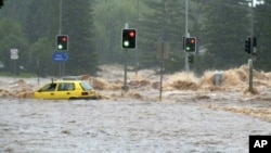 A passenger in a car waves for assistance as a flash flood sweeps across an intersection in Toowoomba, 105 km (65 miles) west of Brisbane, Australia, 10 Jan 2011