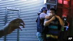 一名警察2019年8月7日在香港深水埗警署外的警民对峙中逮捕了一名示威者。