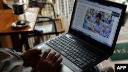 A man reading online news with his laptop at a coffee shop in downtown Hanoi, (File photo).