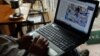 A man reading online news with his laptop at a coffee shop in downtown Hanoi, (File photo).