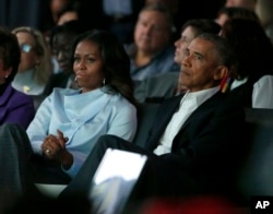 Former President Barack Obama, right, and former first lady Michelle Obama listen to a speaker at the first session of the Obama Foundation Summit in Chicago, Oct. 31, 2017.