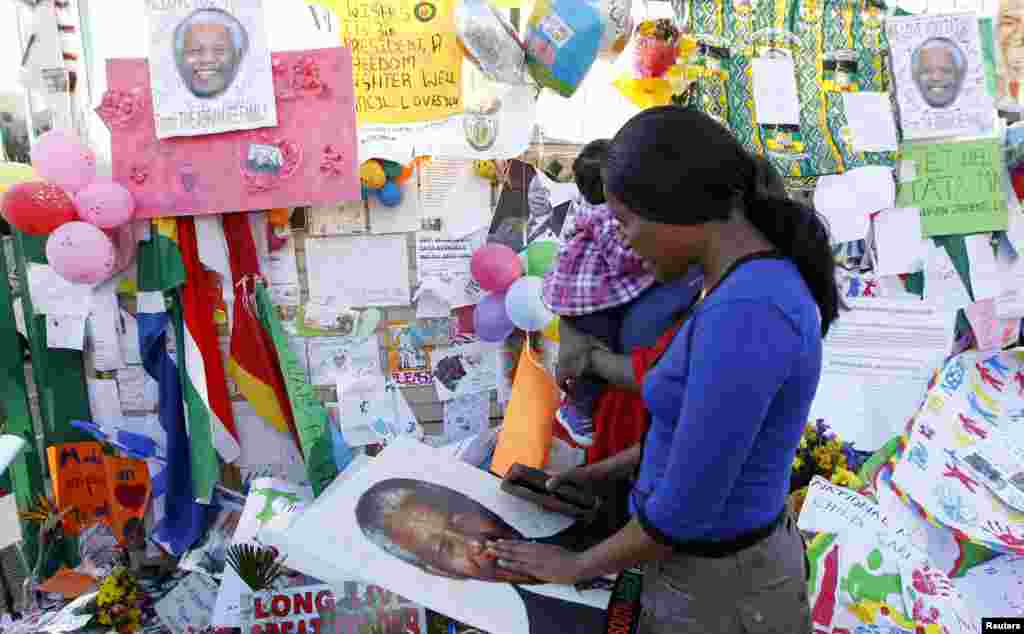 A well-wisher prays in support of ailing former South African President Nelson Mandela in front of the Mediclinic Heart Hospital where he is being treated in Pretoria, July 1, 2013. 