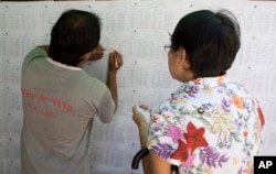 Voters check for their names on a board outside a polling booth in Yangon, Myanmar, Nov. 6, 2015. On Sunday Myanmar will hold what is being viewed as the country's best chance for a free and credible election in a quarter of a century.