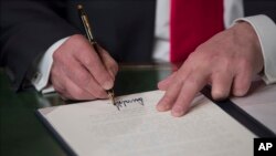 El presidente Trump firma los primeros documentos de su mandato tras ser juramentado en el Capitolio.