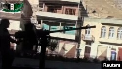 A Syrian rebel fires a heavy machine gun mounted on the back of a vehicle in Maaloula, a suburb of Damascus, in this image taken from video footage obtained from a social media website, September 4, 2013.