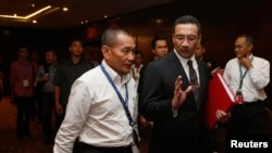 Malaysia's acting Transport Minister Hishamuddin Hussein leaves with Malaysia Airlines Chief Executive Officer Ahmad Jauhari Yahya (L) after a news conference on the search for the missing Malaysia Airlines Flight MH370, March 25, 2014.