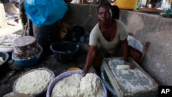 A woman produces cassava flour from cassava in a market in Nigeria.