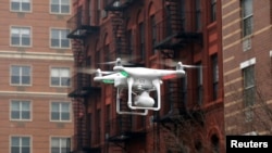 FILE - A drone flies near the scene where two buildings were destroyed in an explosion, in the East Harlem section in New York City, March 12, 2014.