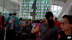 FILE - a flight information board shows cancelled flights due to smoke from Mount Agung at the Ngurah Rai International Airport in Bali, Indonesia.