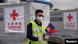 FILE - An airport worker is seen as a Chinese plane arrives with medical workers and supplies donated from China to Cambodia to contain the coronavirus disease (COVID-19) outbreak, at Phnom Penh International Airport in Cambodia, March 23, 2020. REUTERS/Cindy Liu