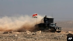 FILE - Iraqi special forces advance in western Mosul, Iraq, Feb. 24, 2017. Forces pushed deeper into western Mosul on Sunday, aiming to capture a bridge across the Tigris. 