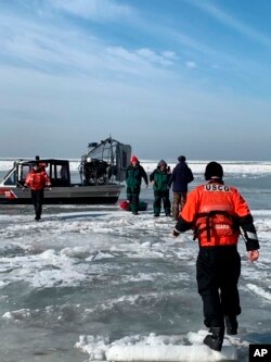 In this photo provided by the U.S. Coast Guard, members from Coast Guard Station Marblehead rescue ice fishermen from an ice floe that broke free from land north of Catawba Island, March 9, 2019, in Ohio. People were rescued by the Coast Guard and local agencies via airboats, and others were able to self-rescue by walking across ice bridges or swimming.