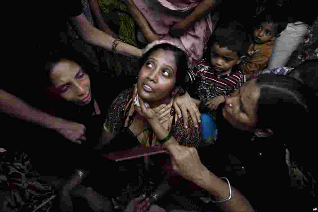 People comfort a woman who lost a family member in a garment factory fire, during a funeral in Karachi, Pakistan, September 13, 2012.