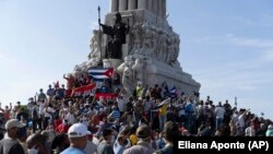 Anti-government protesters gather at the Maximo Gomez monument in Havana, Cuba, Sunday, July 11, 2021. Hundreds of demonstrators took to the streets in several cities in Cuba to protest against ongoing food shortages and high prices of food. (AP Photo/Eliana Aponte)
