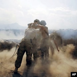 U.S. soldiers from Task Force "Cacti" are enveloped with smoke as they fire 120 mm mortar at Taliban positions from Combat Outpost Penich, in Khas Konar district in Kunar province, eastern Afghanistan, September 30, 2011