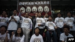 Protesters stand under a banner as they prepare to go on a hunger strike to call for "true" universal suffrage in Hong Kong, March 28, 2014.