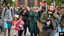 Migrants walk from the main station in Dortmund, Germany