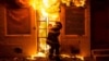 A firefighter uses a saw to open a metal gate while fighting a fire in a convenience store and residence during clashes after the funeral of Freddie Gray in Baltimore, Maryland, April 28, 2015. 