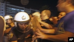 Anti-austerity protesters push police officers outside the Greek parliament following an unscheduled cabinet meeting by Greek Prime Minister George Papandreou to decide on more austerity measures to secure continued funding under an international bailout,