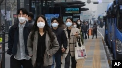 People wearing masks to protect from air pollution walk at a bus station in Seoul, South Korea, Wednesday, March 6, 2019. (AP Photo/Ahn Young-joon)