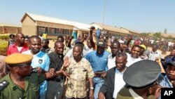 The leader of the Zambian opposition Patriotic Front (PF), Michael "King Cobra" Sata (C), leaves on September 20, 2011 a polling station after inspecting voting procedures in Lusaka during national elections.