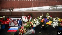 Karangan bunga dan potret pemimpin oposisi Rusia Boris Nemtsov diletakkan di lokasi ia dibunuh dua tahun lalu, sebelah Tembok Kremlin di Moskow (27/2). (AP/Pavel Golovkin)