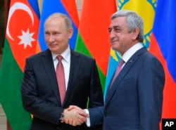 Russian President Vladimir Putin, left, and then-Armenian President Serzh Sargsyan shake hands ahead of an informal meeting of the CIS (Commonwealth of Independent States) leaders at the Novo-Ogaryovo residence outside in Moscow, Russia, Dec. 26, 2017.